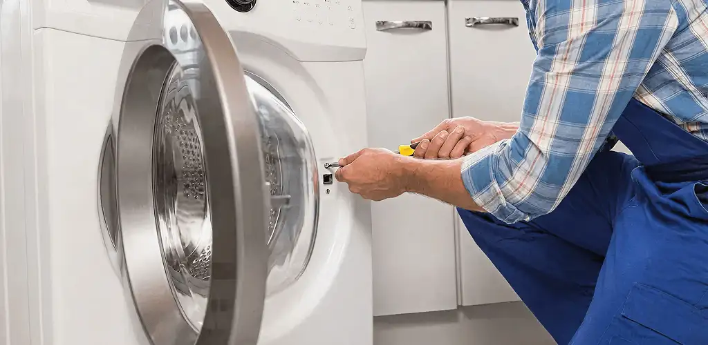 Handyman repairing a clothes dryer and checking electrical connections in Orange, CA