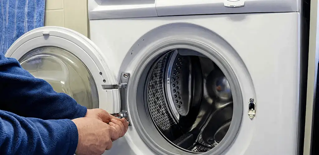 Washing machine repair handyman checking a front-load washer door and latch in Orange, CA
