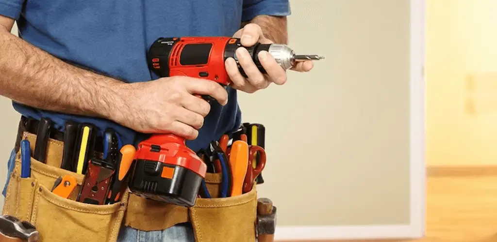 Handyman holding a power drill for home repairs and installations in Orange, CA