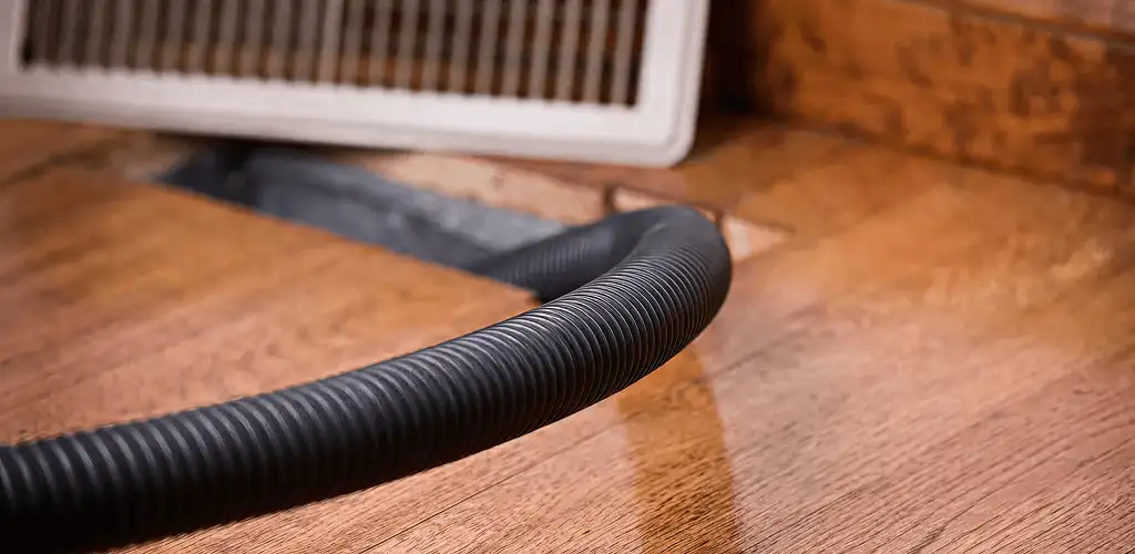 Air duct cleaning hose inserted into a floor vent for ductwork cleaning in Orange, CA